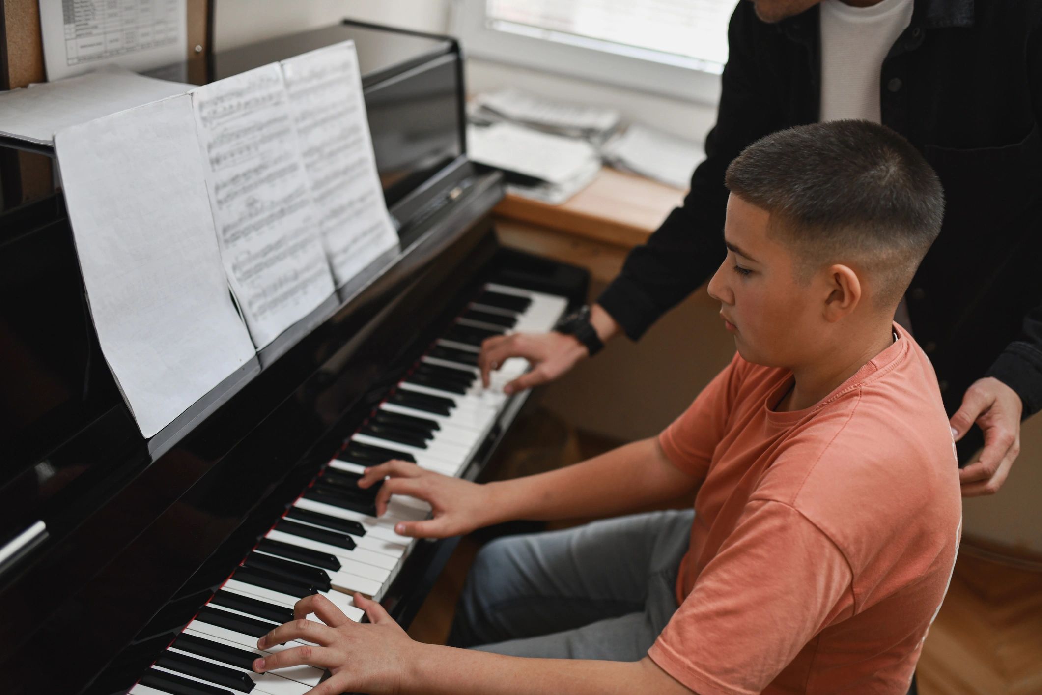 Teacher and student seated at a piano during a lesson